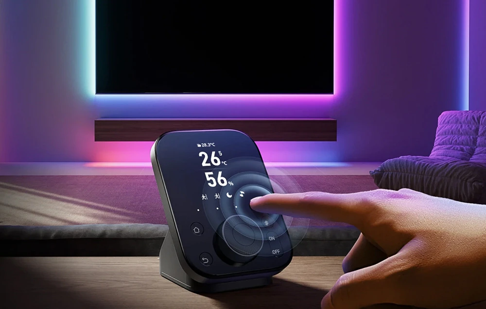 Manevrarea manuală a telecomenzii SwitchBot în fața televizorului cu retroiluminare LED color din camera de zi
