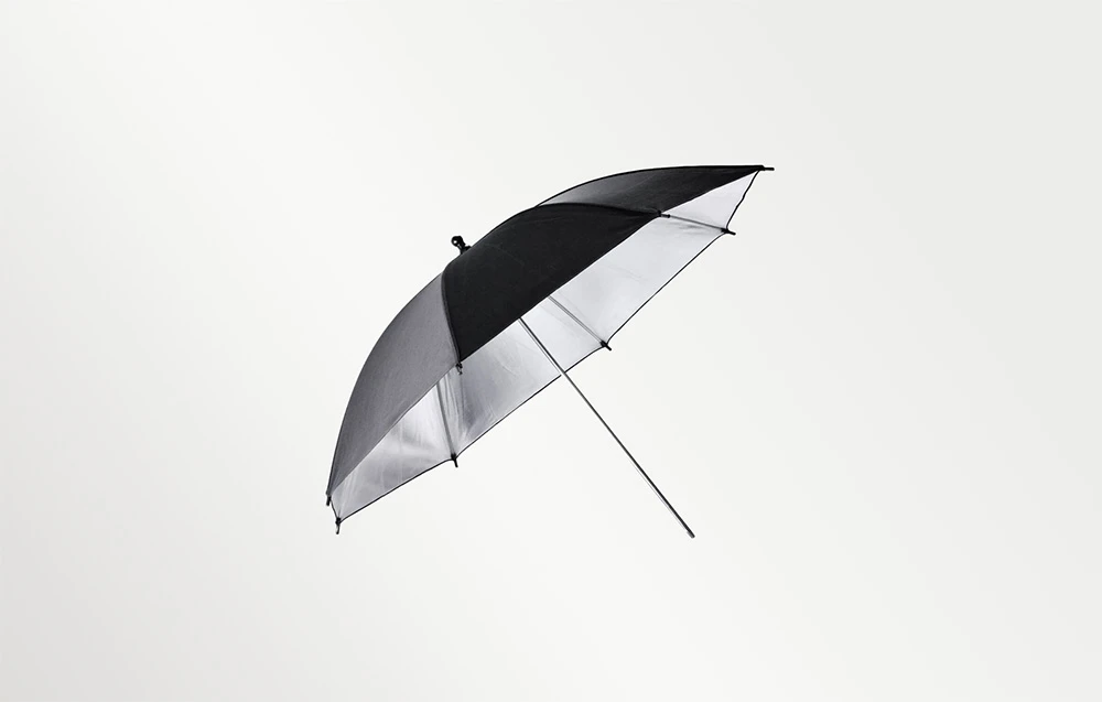 Umbrelă fotografică negru-argintie cu tijă metalică pe un fundal deschis