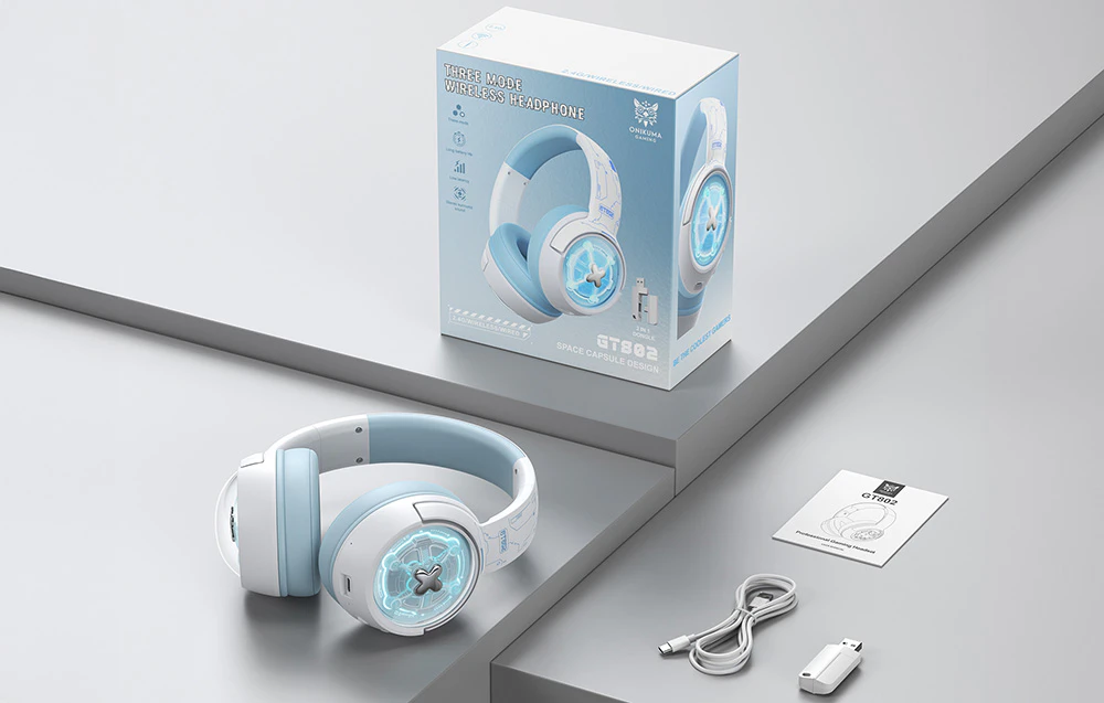 Căști gaming așezate pe o masă gri lângă o cutie, manualul de utilizare, adaptorul USB și cablul