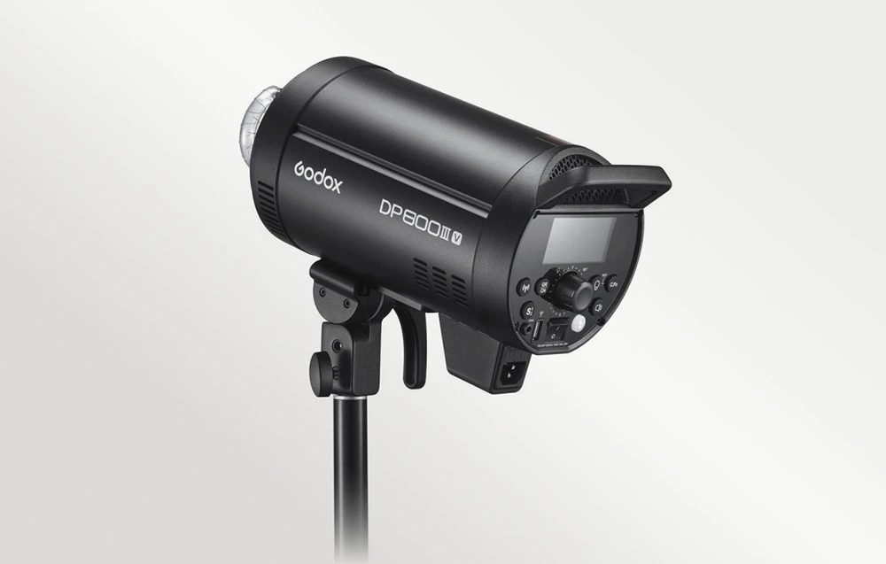Blițul de studio Godox DP800III-V montat pe un trepied, vedere laterală a carcasei negre și a panoului de control