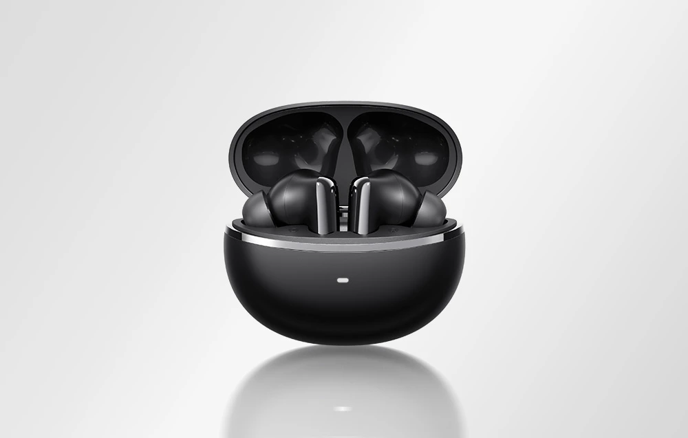 Căști wireless negre plasate într-o carcasă de încărcare neagră deschisă pe un fundal luminos.