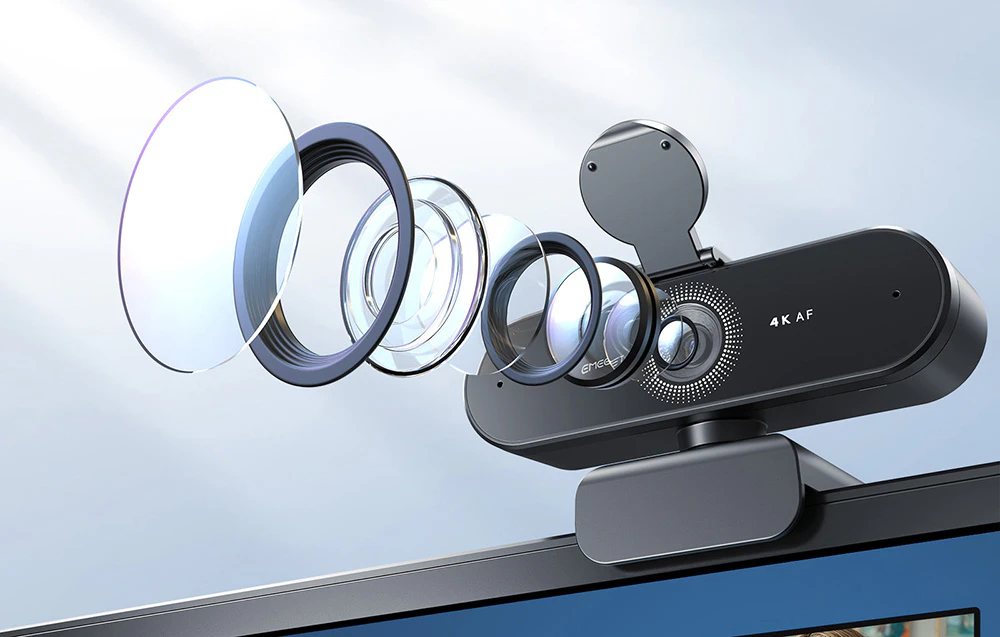 Camera web EMEET cu elemente vizibile ale obiectivului atașată la un monitor pe un fundal albastru