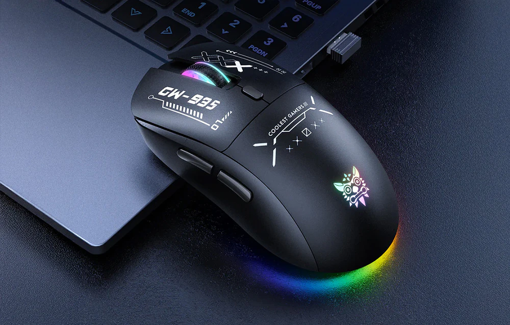Mouse negru pentru jocuri cu iluminare de fundal colorată pe baza unui laptop pe un fundal întunecat