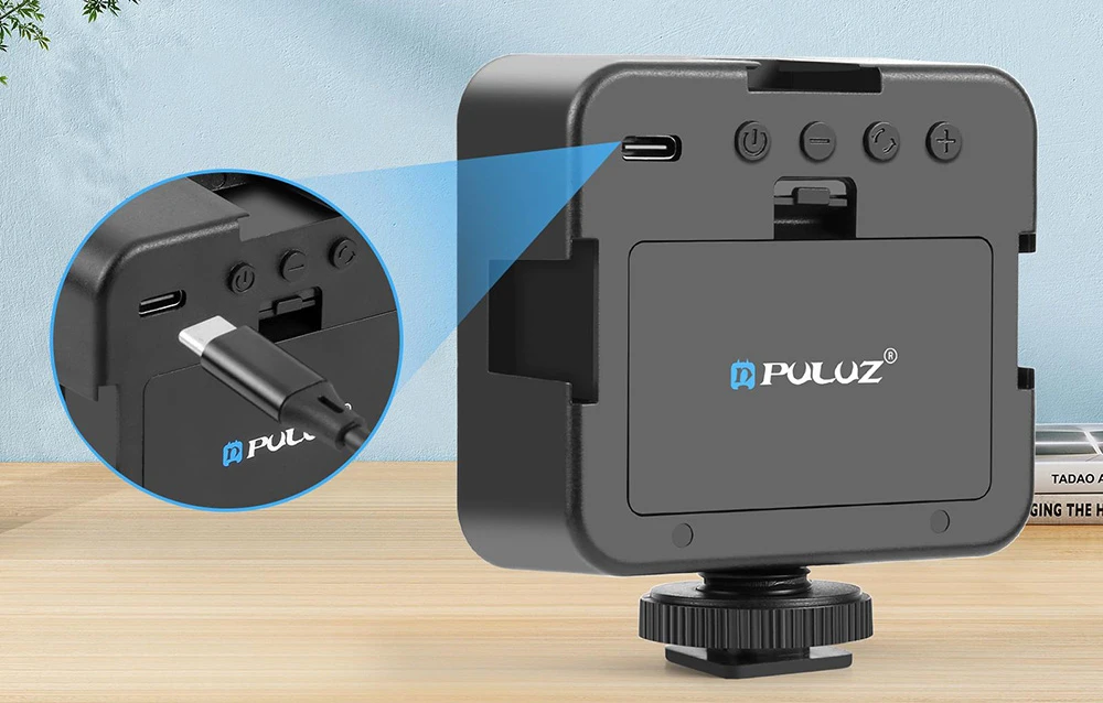 Un dispozitiv PULUZ negru cu un port USB-C prezentat mărit pe un birou din lemn