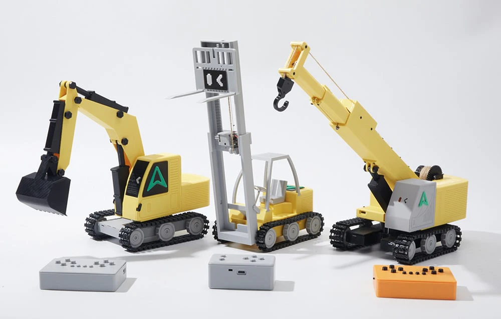 Modele imprimate de utilaje de construcții realizate din blocuri de construcție, create pe o imprimantă 3D.