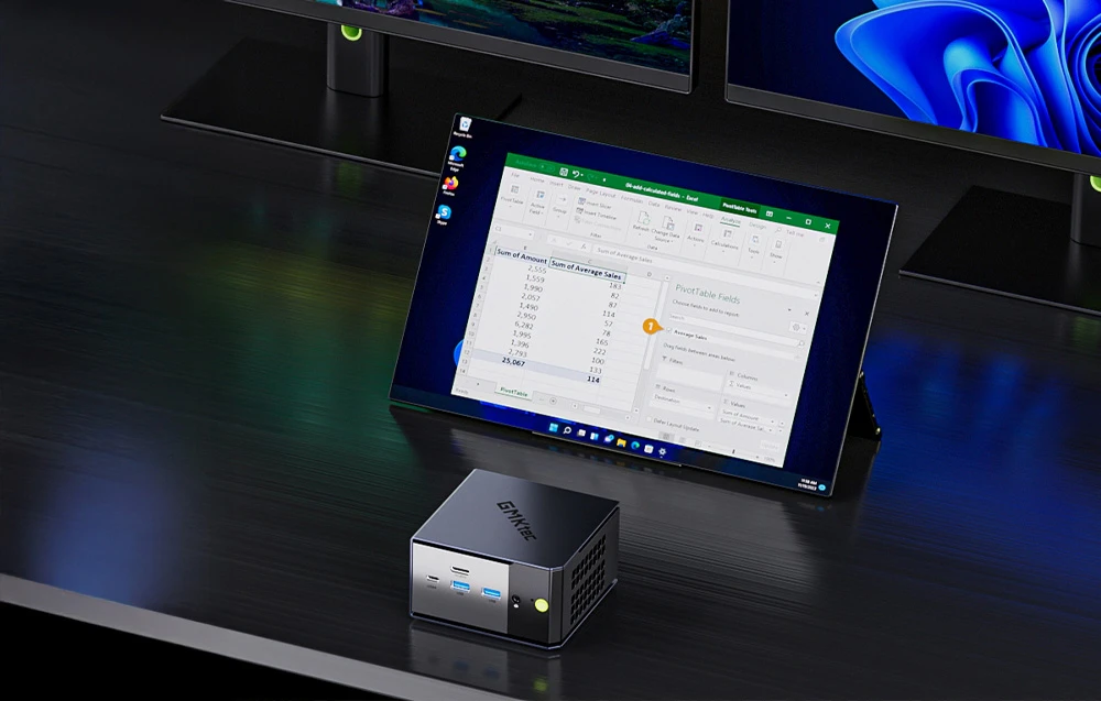 O tabletă sprijinită pe un birou. În fața ei se află Mini PC-ul GMKtec.