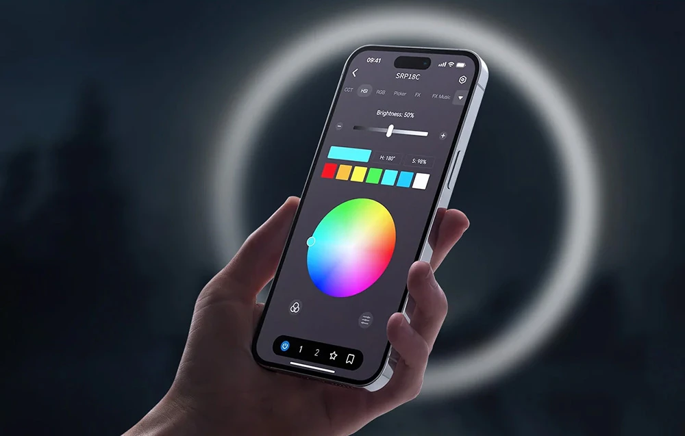 Mâna ține un smartphone cu o aplicație mobilă deschisă pentru a controla culoarea și luminozitatea iluminatului