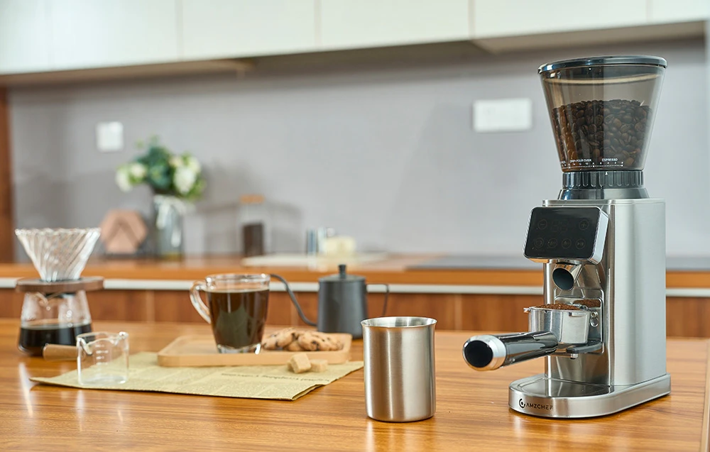 O râșniță de cafea profesională AMZCHEF lângă accesorii de barista pe un blat de bucătărie de culoare deschisă