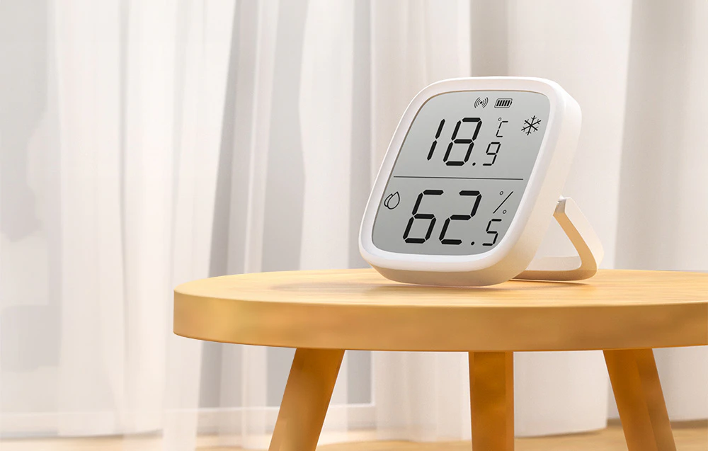 Senzor de temperatură și umiditate pe o masă de lemn într-o cameră luminoasă