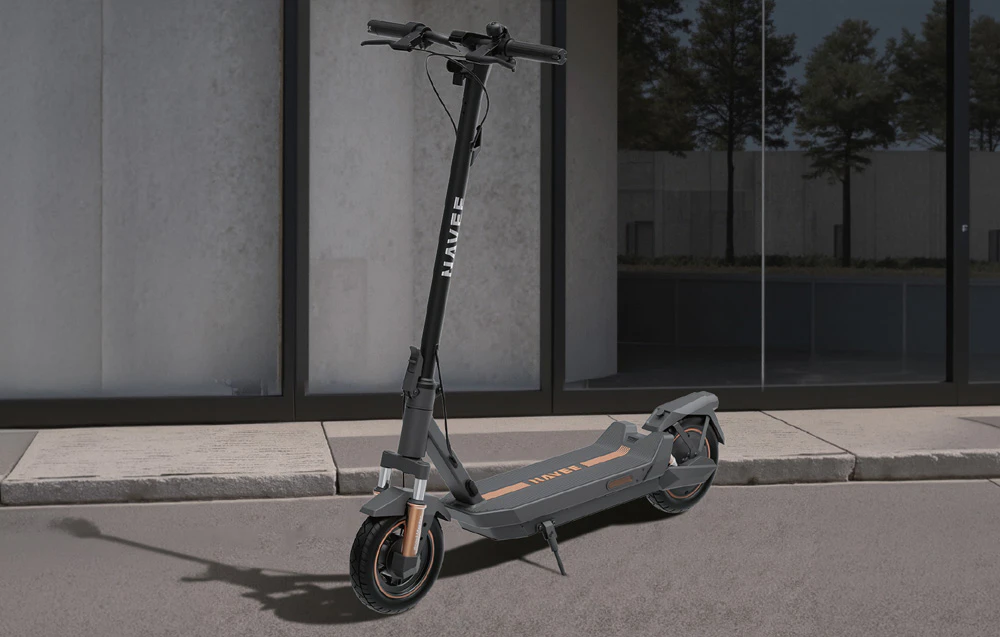 Un scuter electric NAVEE stă pe suportul său lângă o clădire modernă