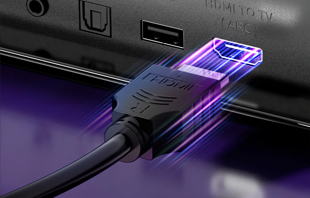 Prim-plan al unui cablu HDMI cu efect luminos, conectat la portul barei de sunet.