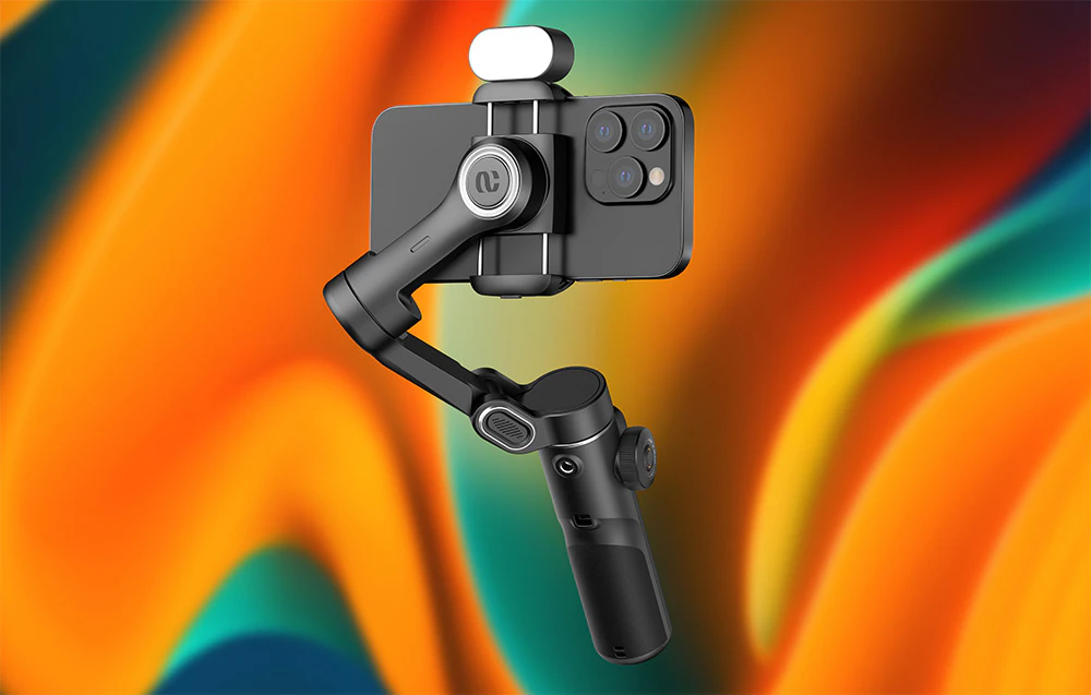 Un gimbal negru cu un smartphone și o lumină atașată în partea de sus, pe un fundal colorat cu gradient.