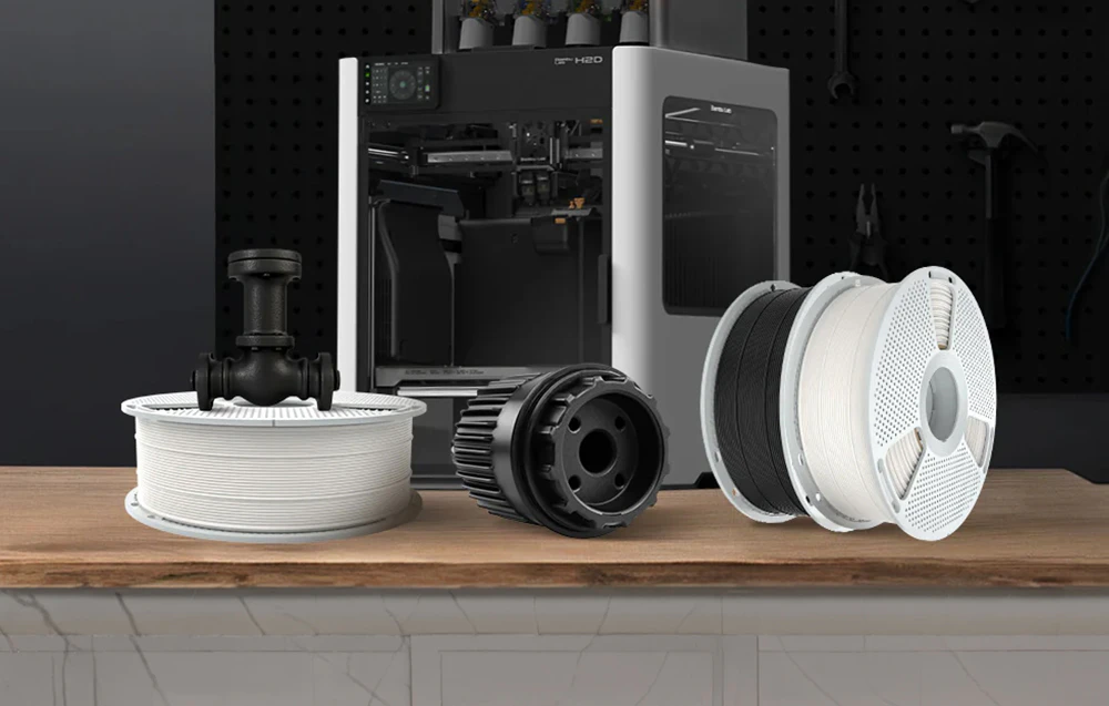 O imprimantă 3D într-un atelier, lângă bobine de filament SUNLU PC-ABS și imprimate industriale durabile