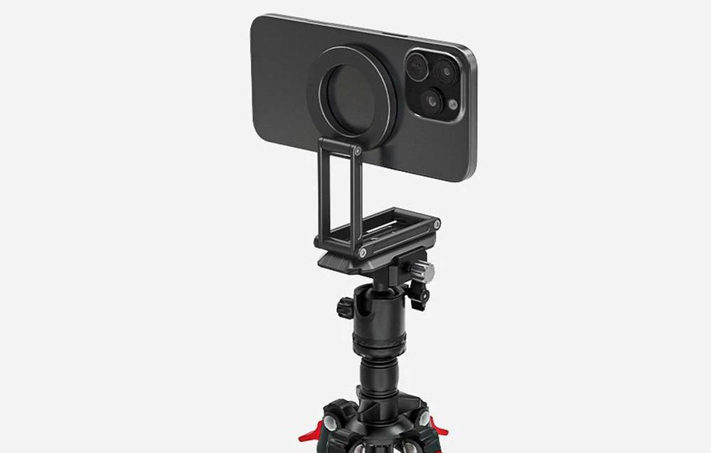 iPhone negru montat pe suport și trepied pe fundal gri