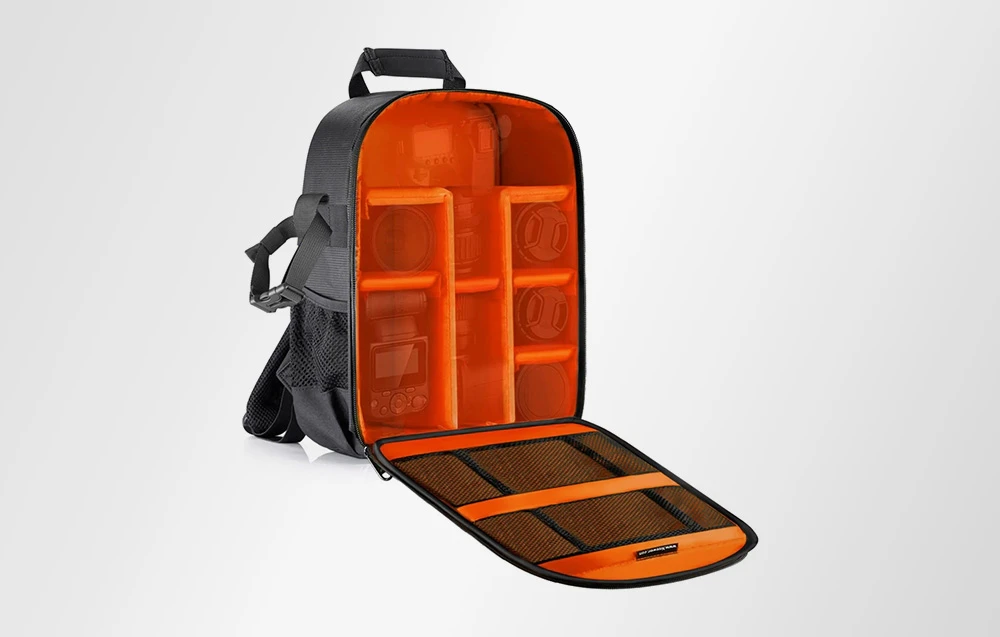 Un rucsac deschis pentru aparat foto, cu interior portocaliu și compartimente pline cu echipament fotografic.