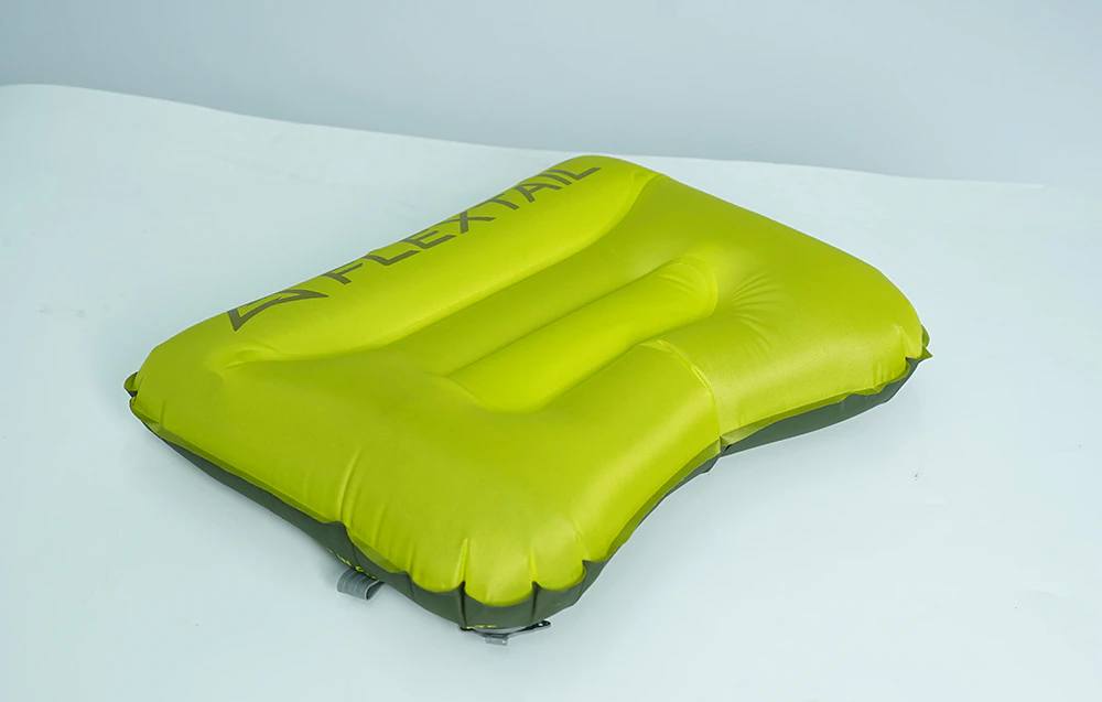 O pernă de călătorie Flextail de culoare verde deschis, cu o formă ergonomică, vedere de sus pe un fundal deschis