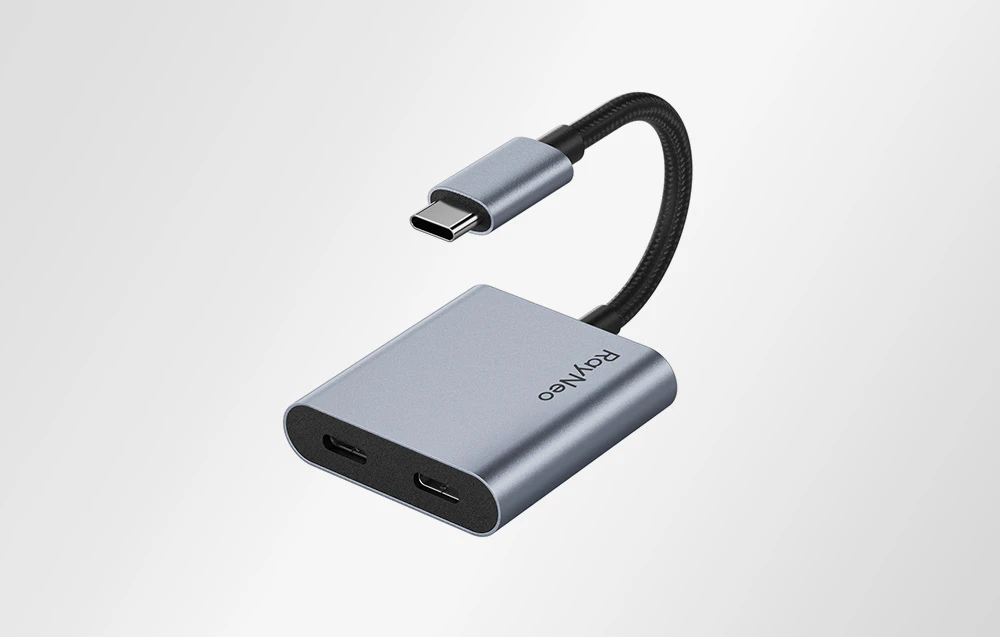 Adaptor RayNeo USB-C cu două porturi, prezentat pe un fundal luminos într-un prim plan ușor.
