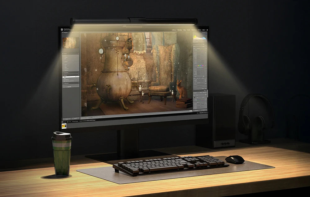 Monitor cu o lampă pe birou, afișând un software de editare foto
