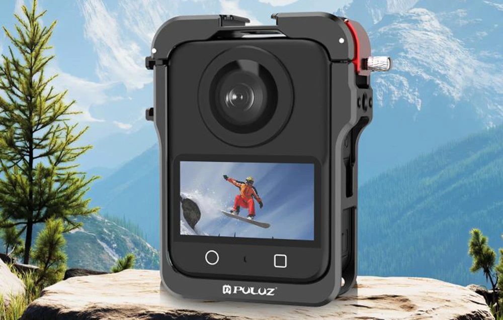 Cameră în cușcă de protecție cu imaginea unui snowboarder pe ecran pe un peisaj montan