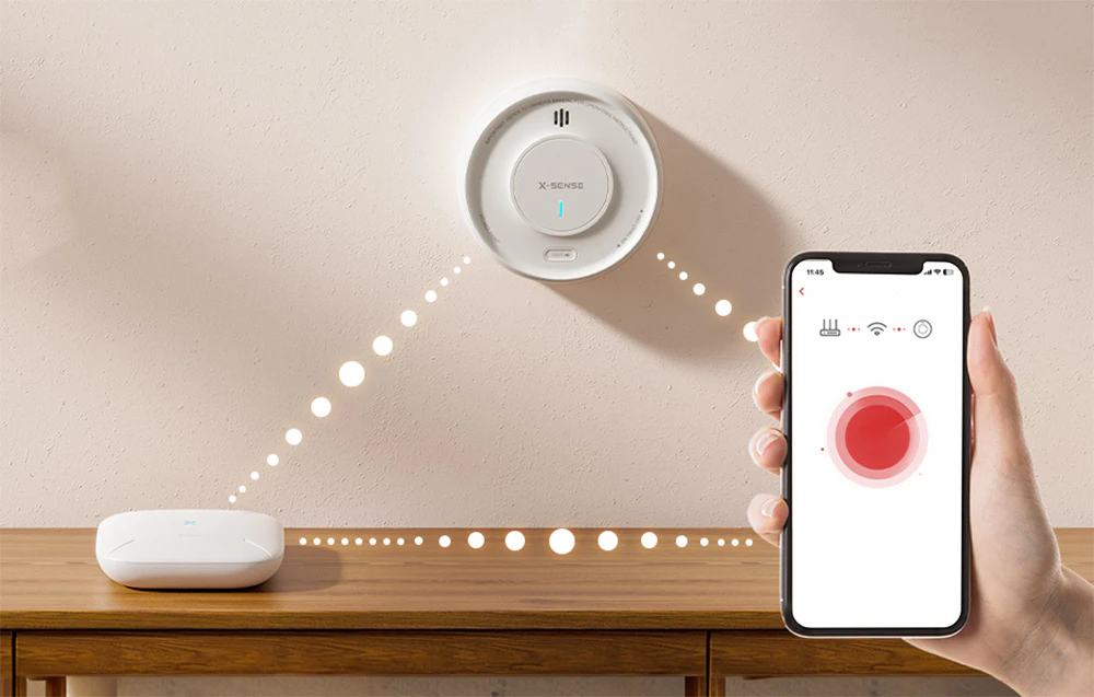 Senzorul de perete X-Sense comunicând wireless cu stația de bază și cu aplicația mobilă de pe un smartphone