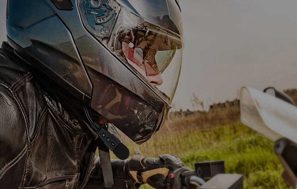 O persoană care poartă o cască conduce o motocicletă și poartă căști Ejeas