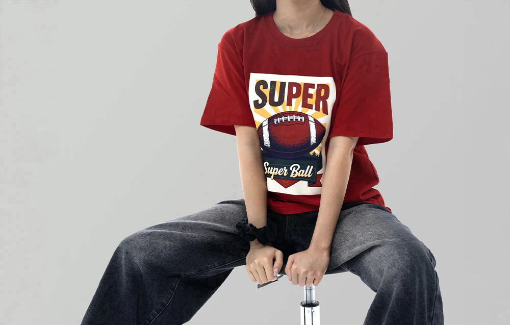 O femeie poartă un tricou roșu cu un imprimeu de fotbal și cuvintele