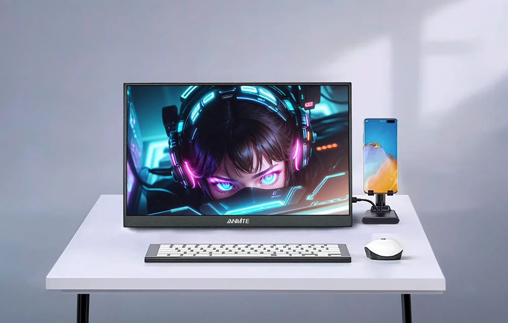 Un monitor așezat pe un birou alb, lângă un telefon în poziție verticală, o tastatură și un mouse.