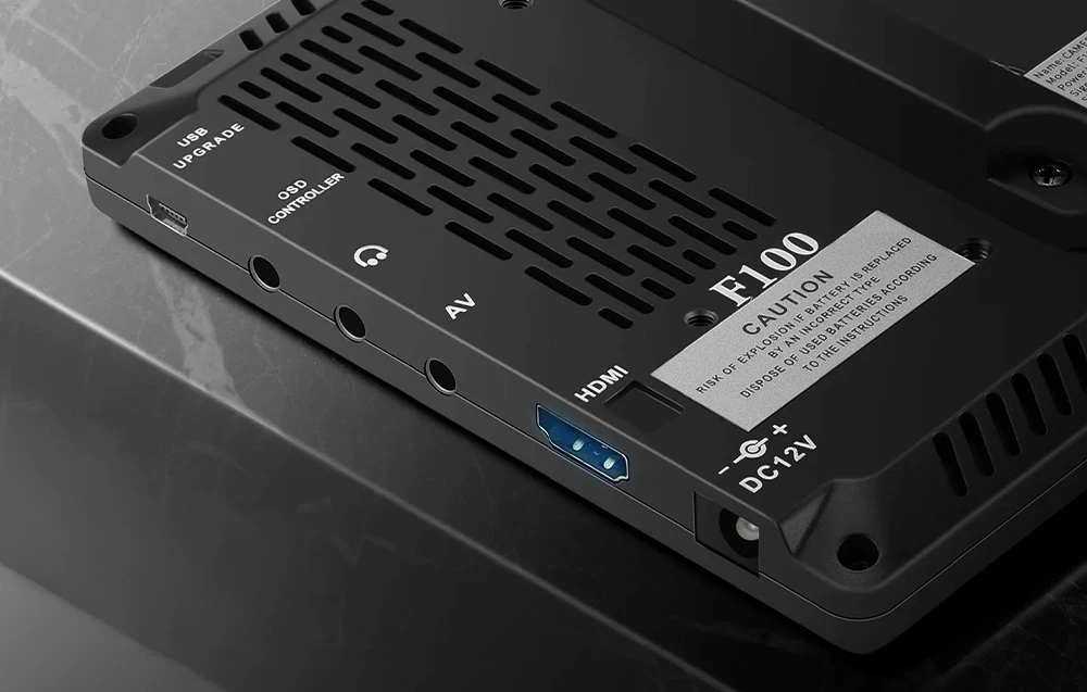 Detaliu al panoului inferior al modelului F100, care prezintă porturile: HDMI, AV, mufă pentru căști și priză de alimentare de 12 V c.c.