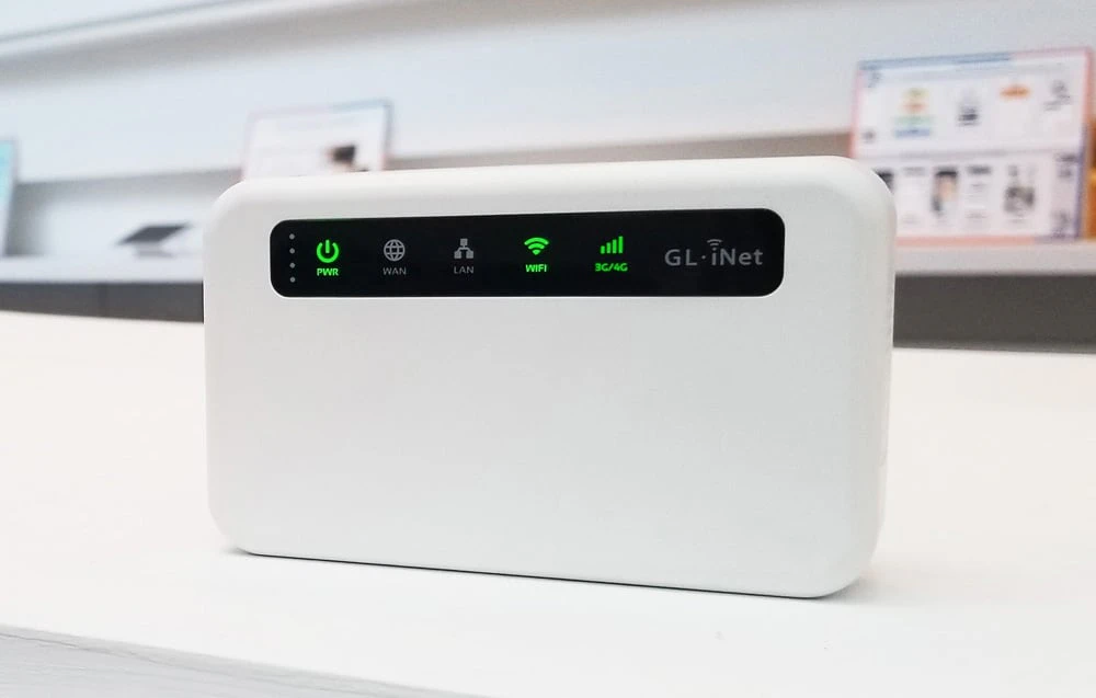 O imagine în prim-plan din față a unui router alb cu un panou negru, pe care pictogramele PWR, WIFI și 3G/4G sunt iluminate în verde.