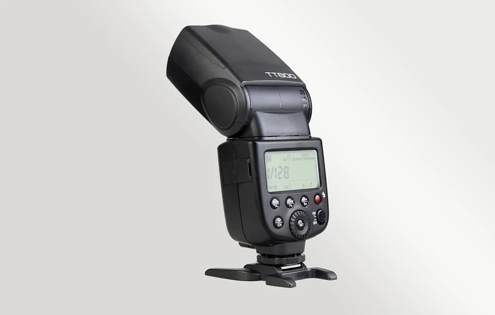 Blițul Godox TT600 montat pe un stativ cu ecranul LCD iluminat