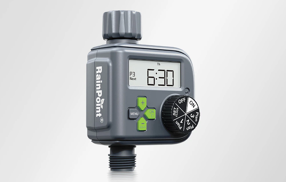 Un controler de irigare RainPoint® de culoare grafit, cu butoane verzi vizibile și un cadran de selectare a programului pe un fundal gri deschis