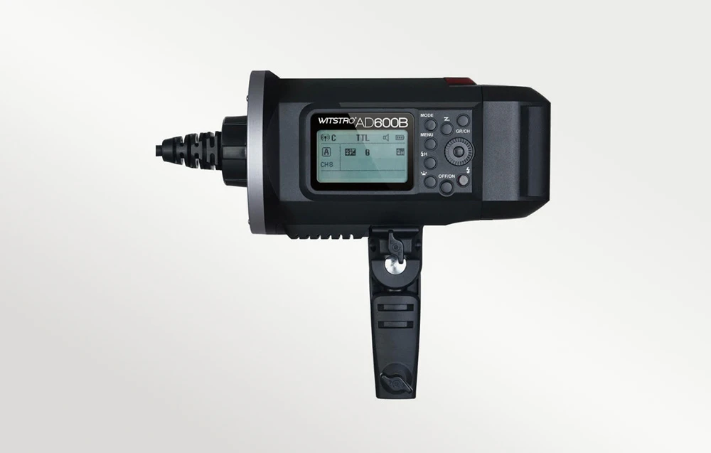 Vedere laterală a blițului Godox Witstro AD600B cu suportul pentru trepied rabatat și panoul de control LCD vizibil