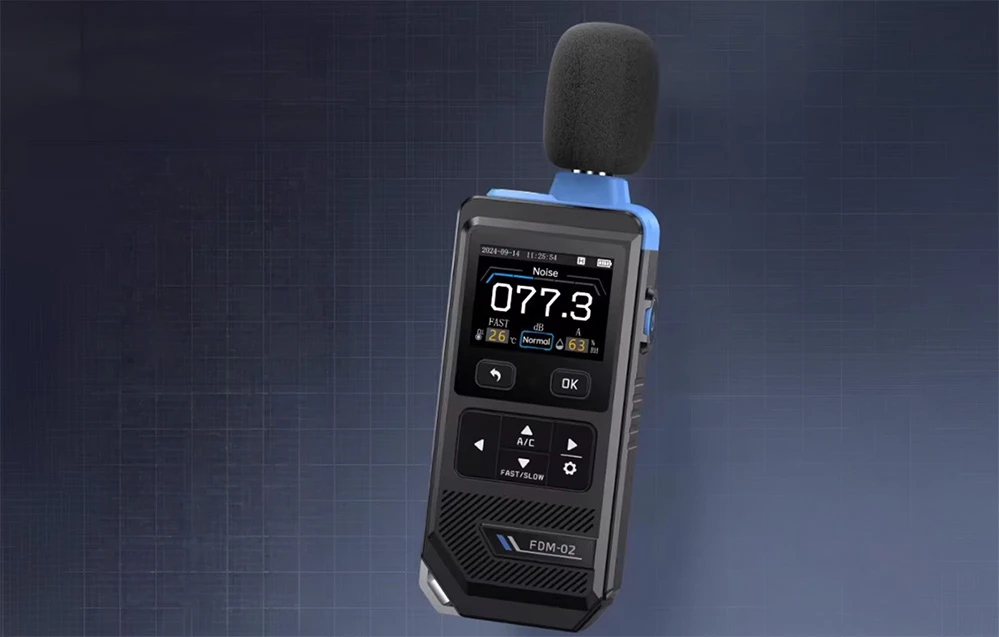 Sonometru portabil cu microfon acoperit cu spumă, afișând o valoare de 77,3 dB pe un fundal întunecat, texturat