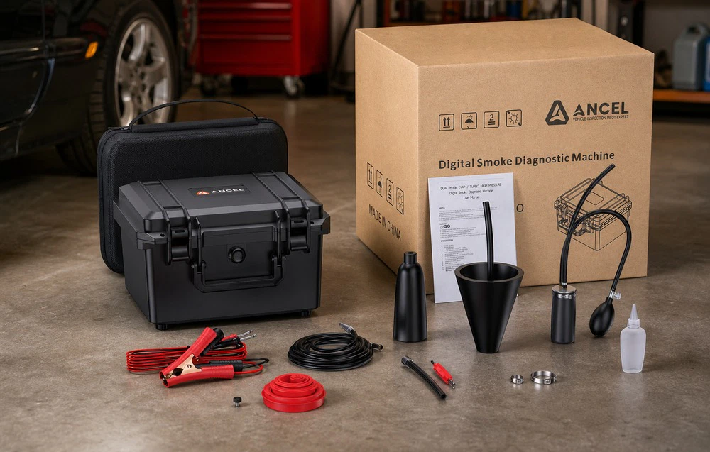 Un generator de fum pentru diagnosticare Ancel într-o trusă, împreună cu un set de accesorii și cutia sa originală, așezat pe podeaua atelierului
