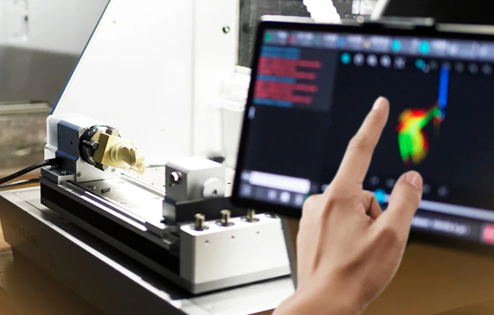 Mână folosind un ecran de router CNC, lângă modulul cu 4 axe