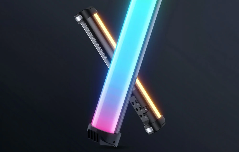 Două lămpi alungite care se intersectează — una emite lumină multicoloră, iar cealaltă emite lumină caldă, galbenă.