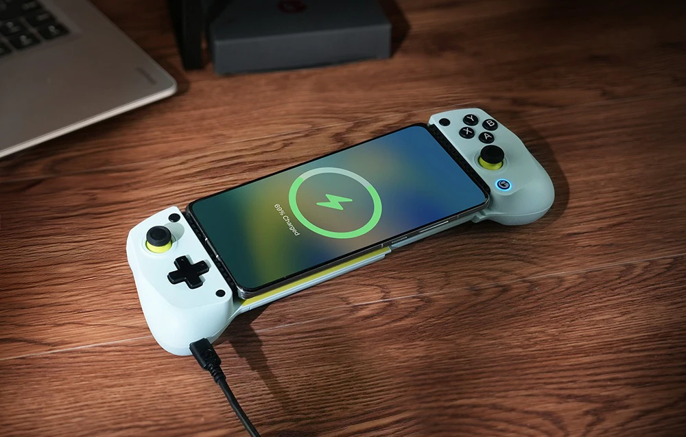 Un smartphone care se încarcă într-un controler GameSir montat pe o suprafață de lemn.