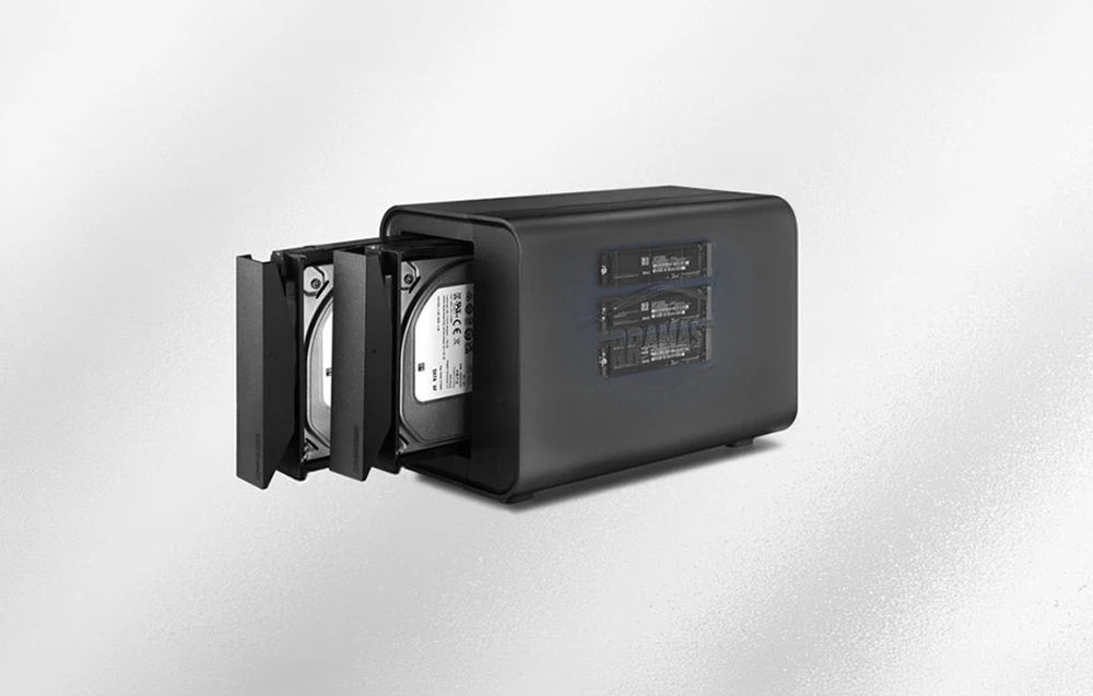 Carcasă cu două compartimente pentru unități, cu hard disk-uri glisante și module SSD M.2 vizibile printr-o fereastră laterală