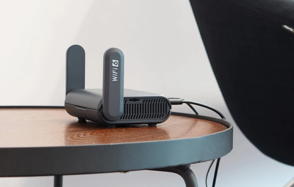 Router negru așezat pe o masă maro