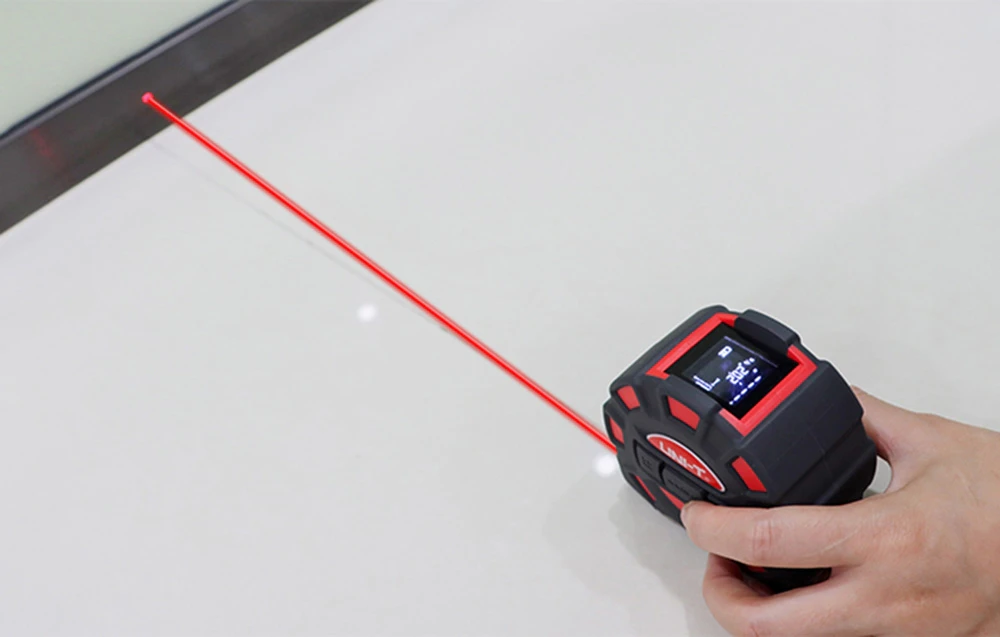 O persoană măsoară o distanță pe podea folosind un telemetru cu laser Uni-T.