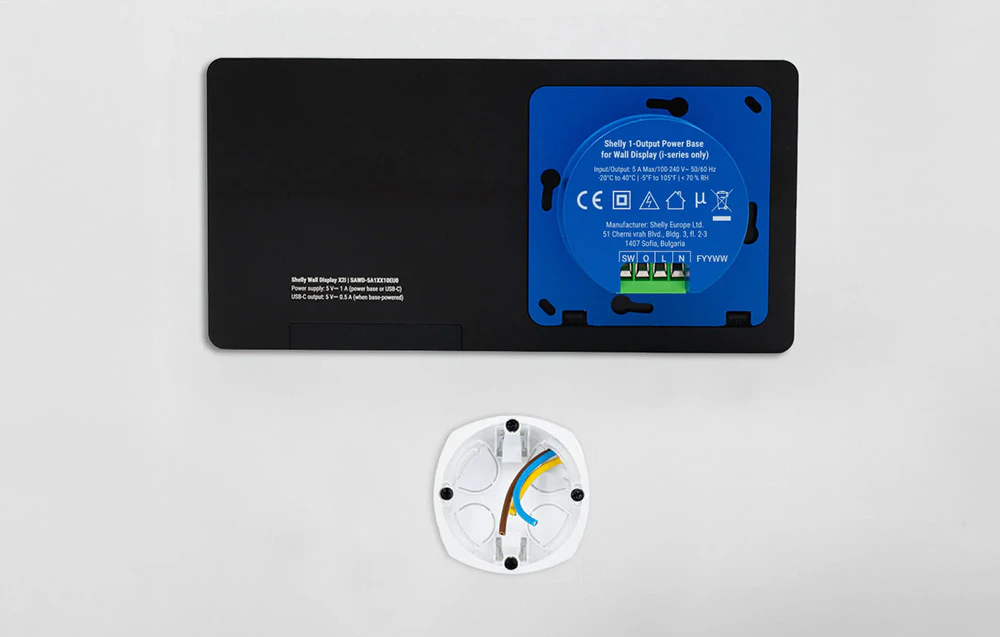 Partea din spate a panoului Shelly Wall Display X2i cu baza de alimentare și schema de cablare din cutia electrică vizibile.