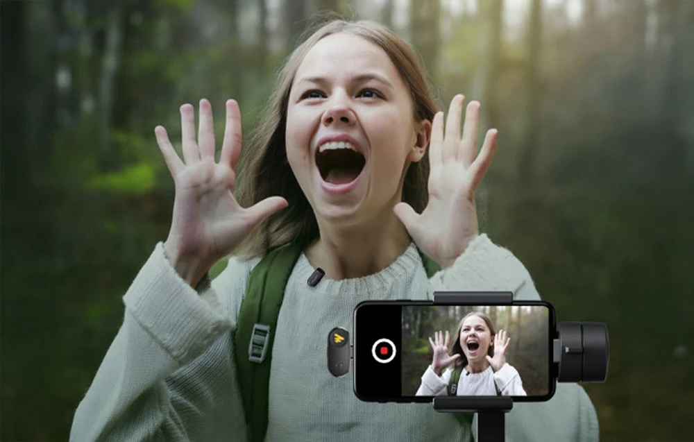 o femeie care țipă aflată în pădure, înregistrată cu un smartphone și microfonul Maono WM622 PC2