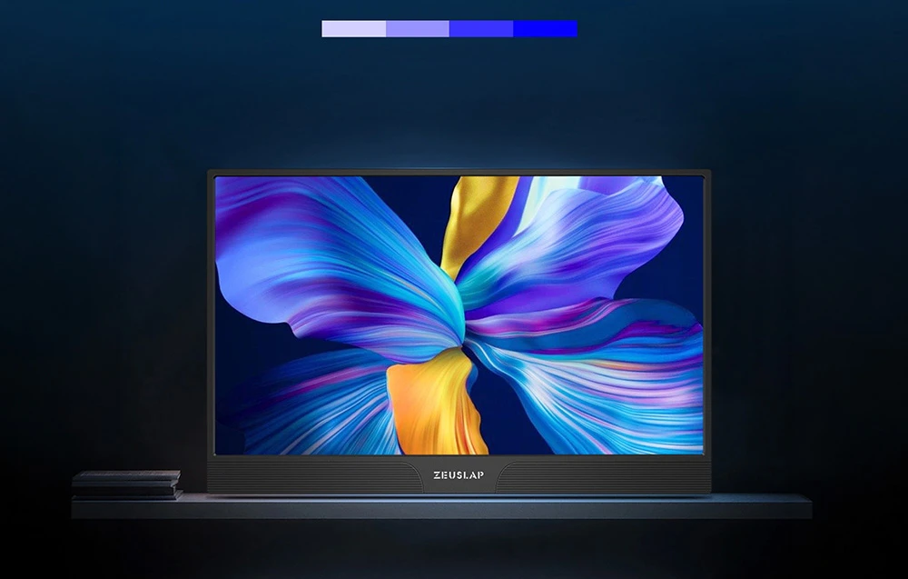 Un monitor portabil ZEUSLAP pe un raft de culoare închisă, afișând grafică florală abstractă și colorată