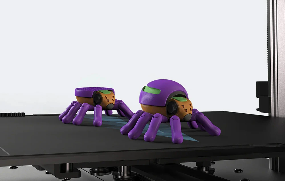 Figurine violet, asemănătoare unor păianjeni, imprimate cu o imprimantă 3D.