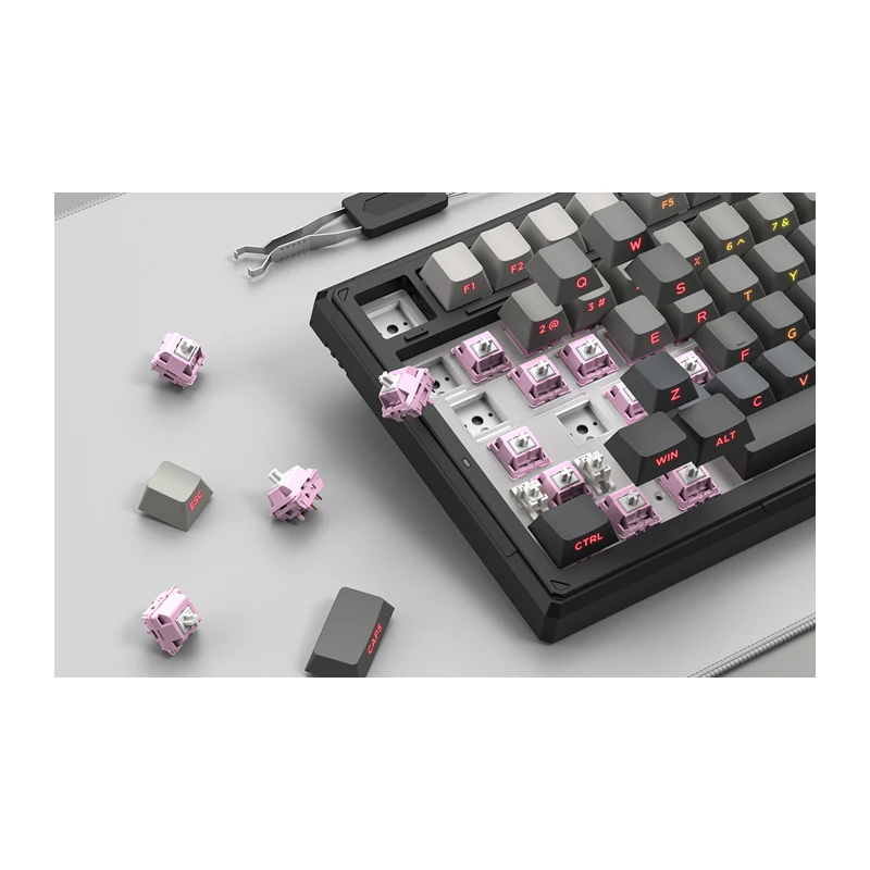 Tastatură neagră cu comutatoare înlocuibile pe o masă gri lângă un instrument de îndepărtare a tastelor