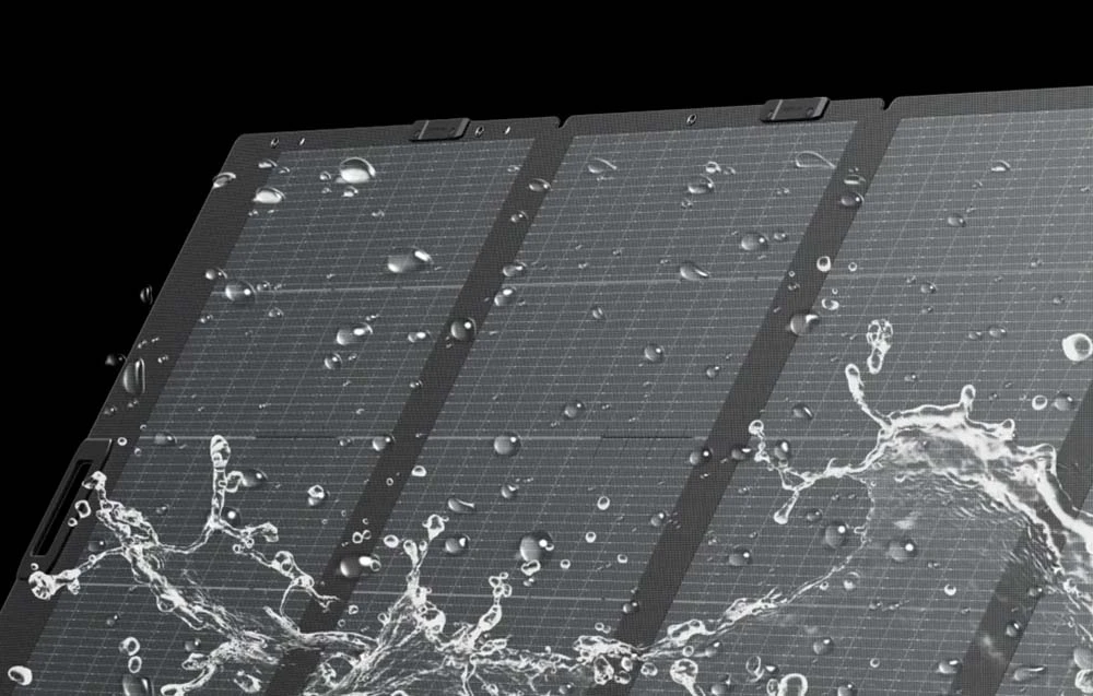 Un panou solar stropit cu apă pe un fundal negru