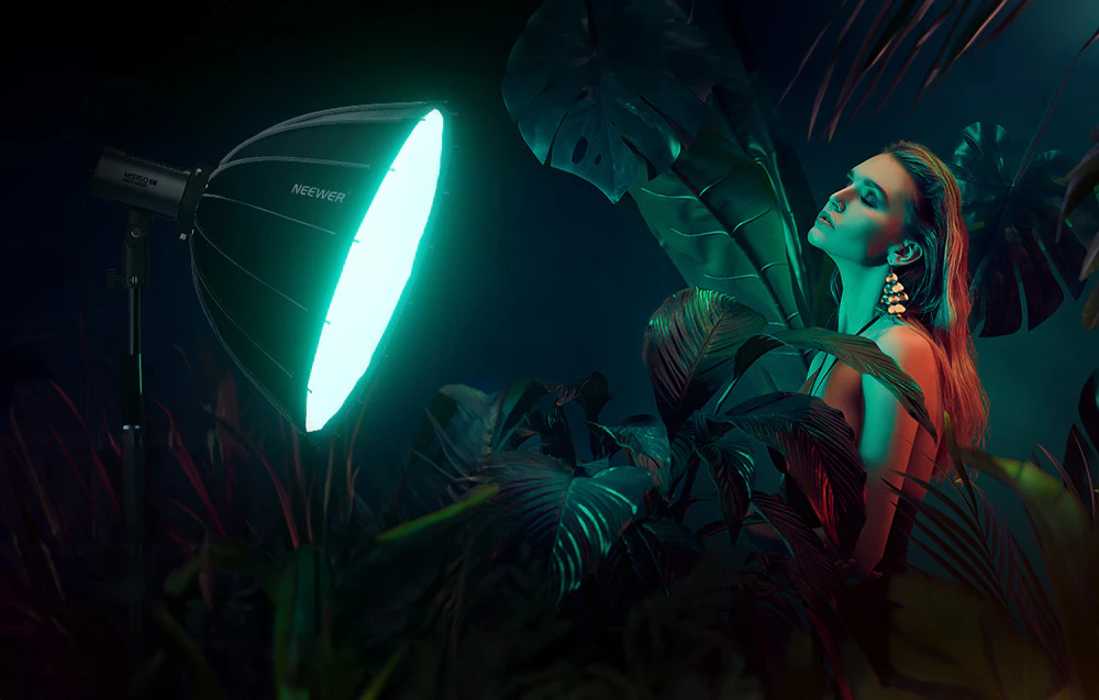 Model în decor tropical iluminat cu lumină verde de la lămpile Neewer, printre frunze de monstera