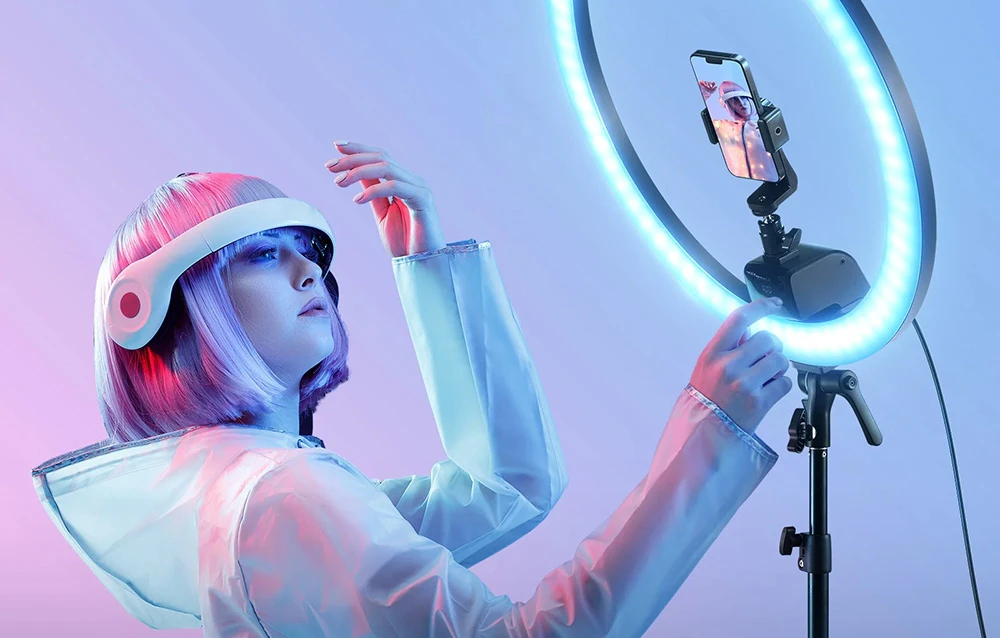 O femeie îmbrăcată într-o ținută futuristă pozează între două lumini inelare Neewer de mari dimensiuni