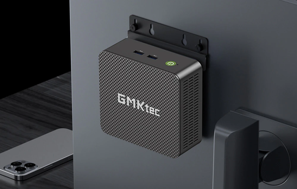 Computer GMKtec montat pe spatele unui monitor pe un suport special, vedere de sus