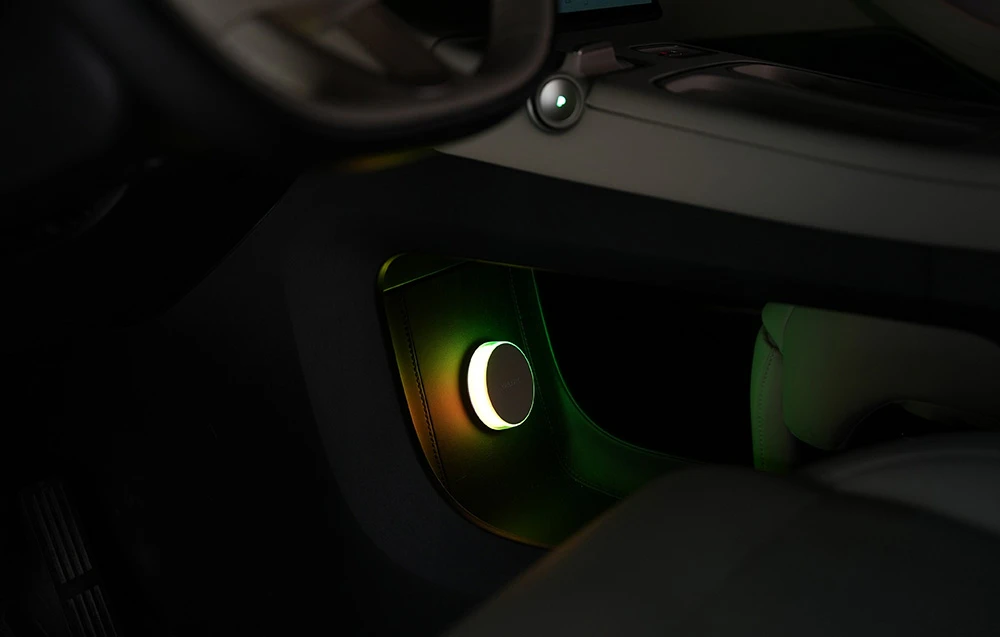 Lampă de noptieră Yeelight Vega montată pe partea inferioară a tabloului de bord al mașinii, iluminată cu lumină verde-galben.